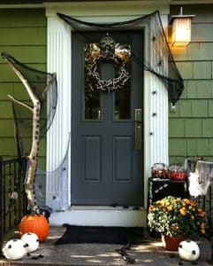 front door of a green house decorated for Halloween